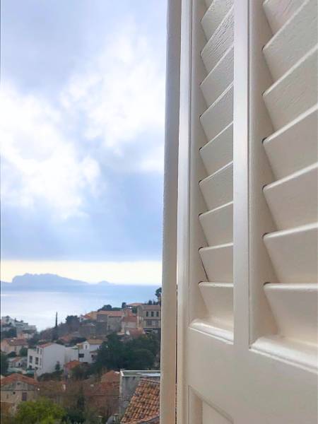 Volets persiennes à lames à l’américaine installés sur une maison située sur les hauteurs de Marseille avec vue sur la mer
