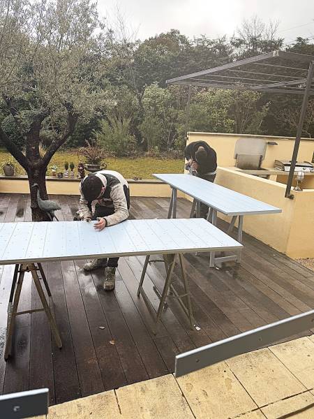 Nos Artisans entrain de poser des volets provençaux lors d'un chantier traditionnel de pose