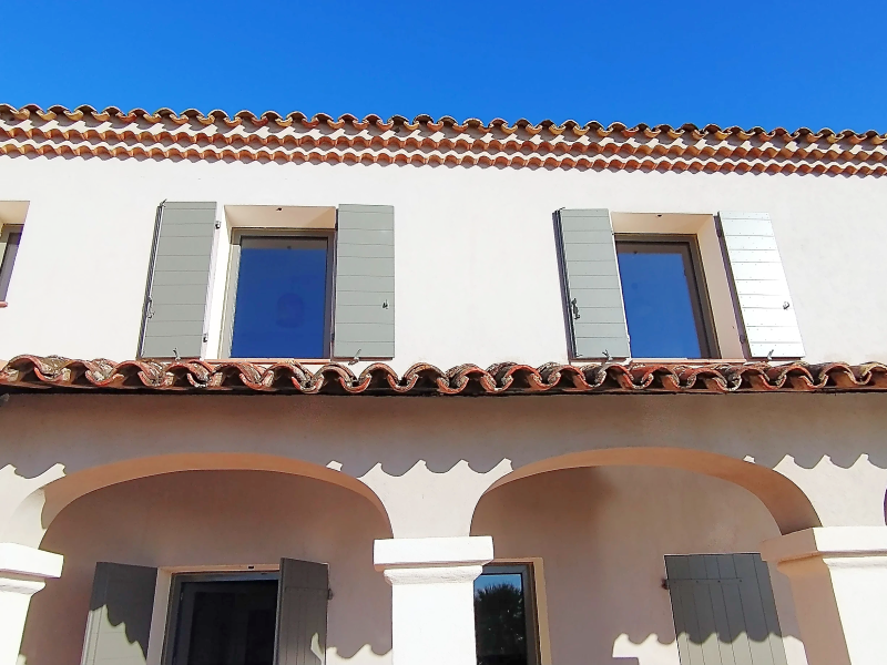 Volets gris vert sur une façade provençale blanche à Cassis